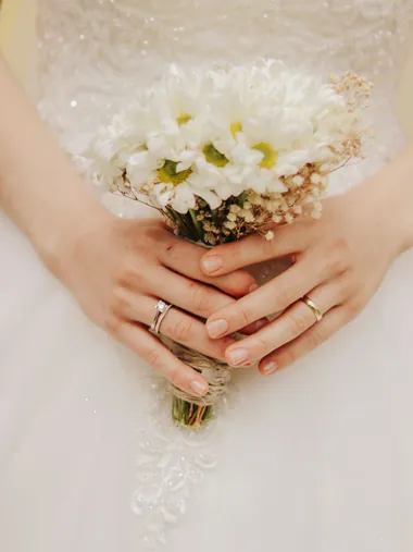 Pengantin memegang buket bunga putih